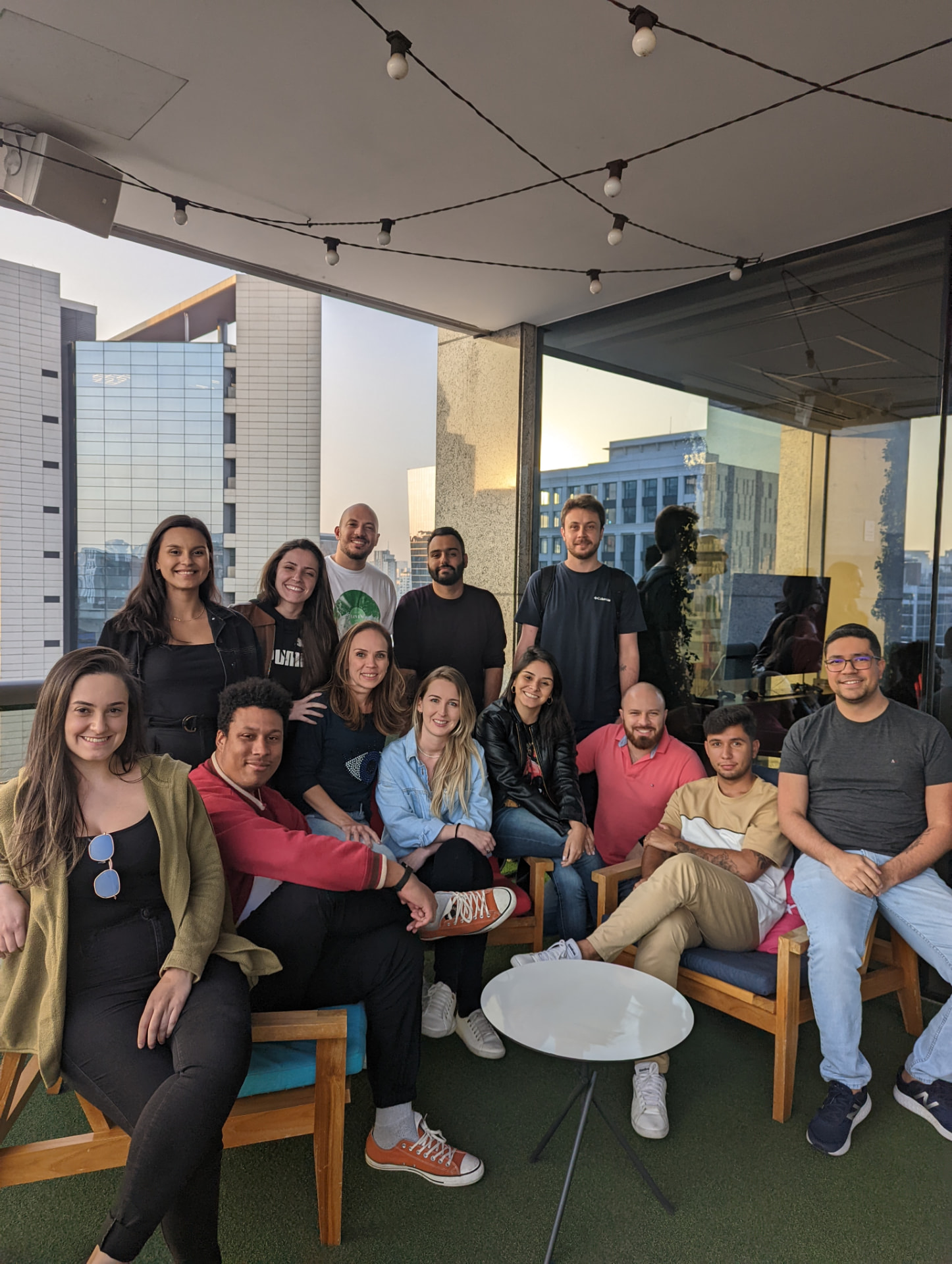 Time reunido em terraço de escritório ao pôr do sol